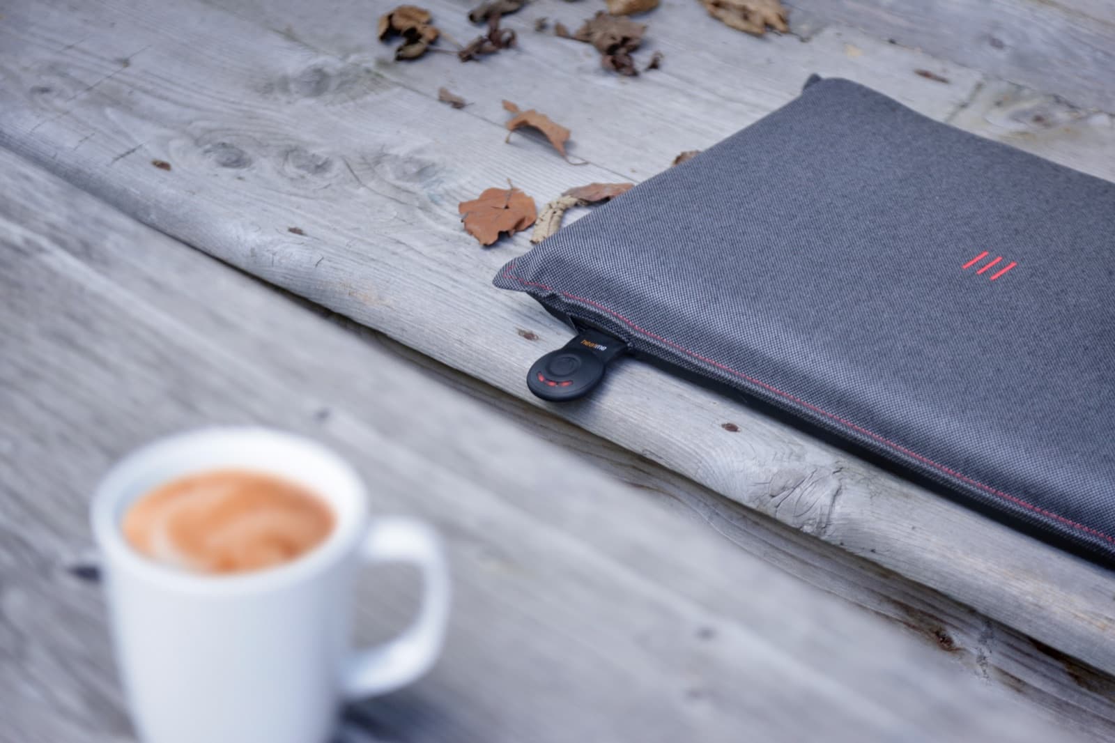 heatme Smart Kissen neben Cappuccino auf Holztisch